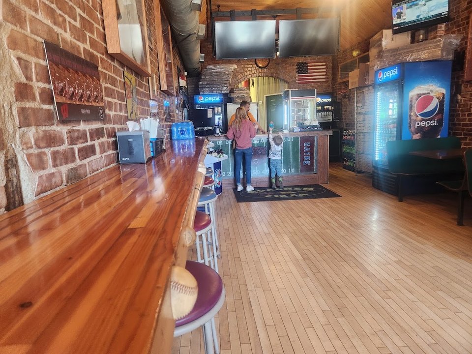 Pizza restaurant interior with simple tables and chairs.